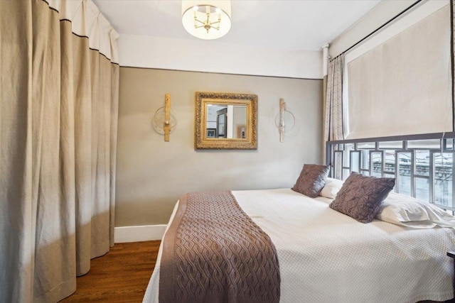 bedroom featuring dark hardwood / wood-style flooring and an inviting chandelier