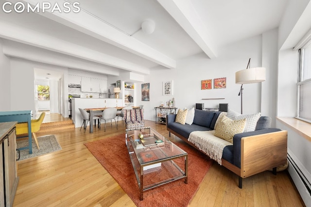 living room with beam ceiling, baseboard heating, and light hardwood / wood-style flooring