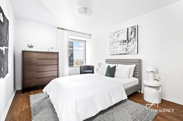 bedroom with wood finished floors and baseboards