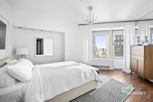 bedroom featuring an inviting chandelier, visible vents, and dark wood finished floors