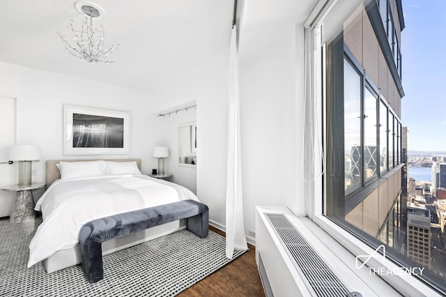 bedroom featuring an inviting chandelier and wood finished floors