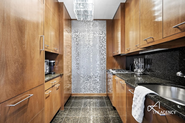 150 W 56th St Unit 5603, New York City, NY 10019 - kitchen with brown cabinetry, backsplash, and dark stone countertops
