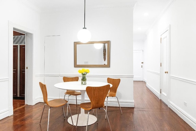 dining area featuring dark wood finished floors and crown molding