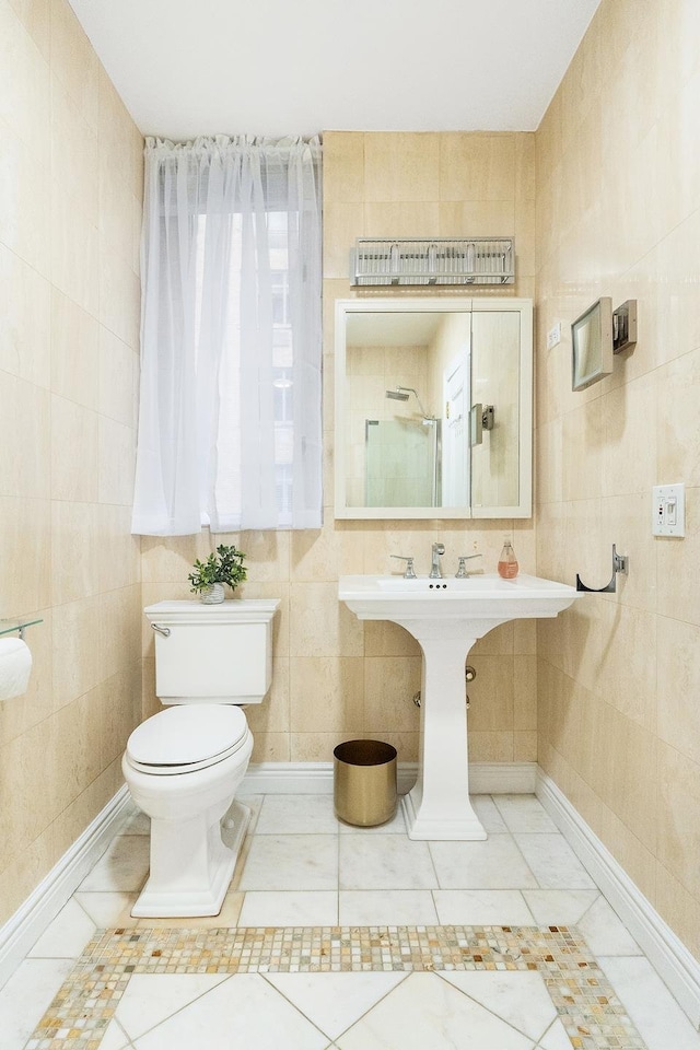 bathroom featuring tile walls and toilet