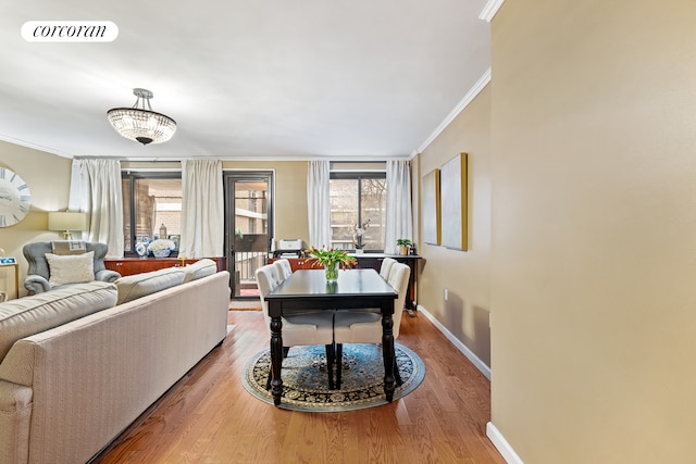 living room with ornamental molding, wood finished floors, visible vents, and baseboards