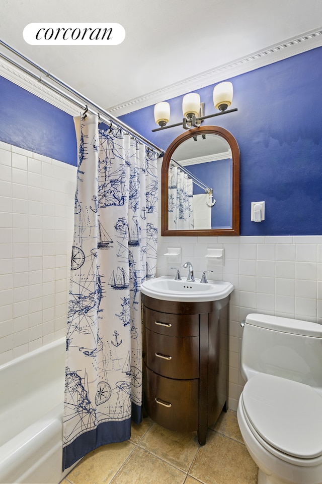 bathroom featuring toilet, tile patterned flooring, shower / bathtub combination with curtain, vanity, and tile walls