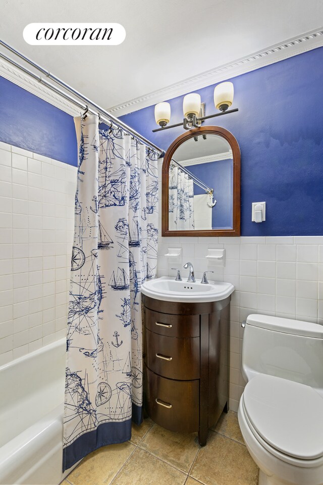 full bath featuring tile patterned flooring, toilet, vanity, tile walls, and shower / tub combo with curtain