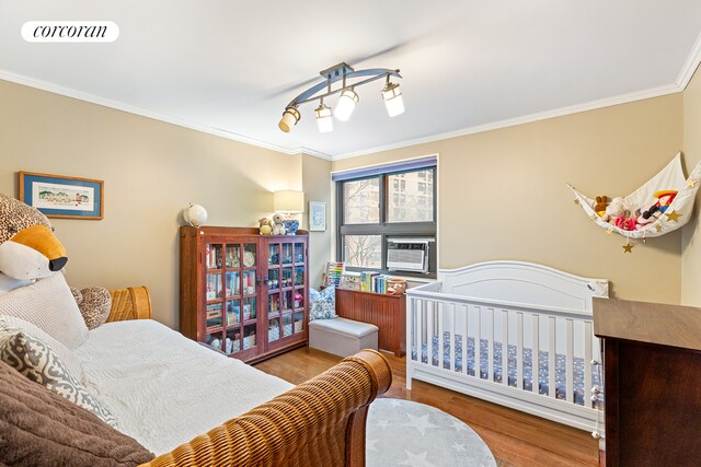 bedroom featuring ornamental molding, visible vents, and wood finished floors