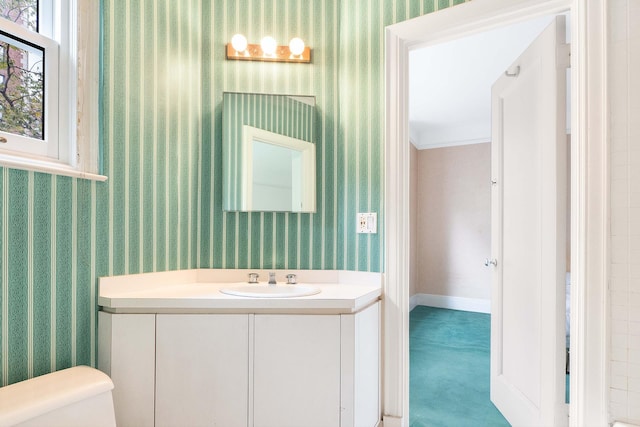 bathroom with wallpapered walls, vanity, and toilet