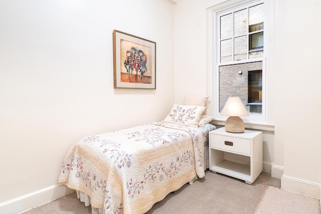 bedroom featuring light colored carpet and baseboards