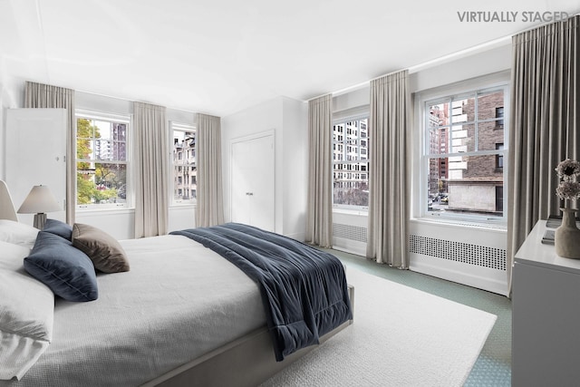 bedroom featuring light colored carpet and baseboards
