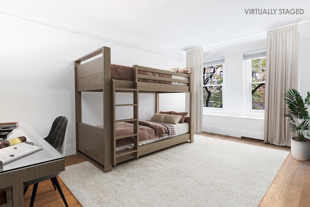 bedroom featuring a desk, wood finished floors, and baseboards