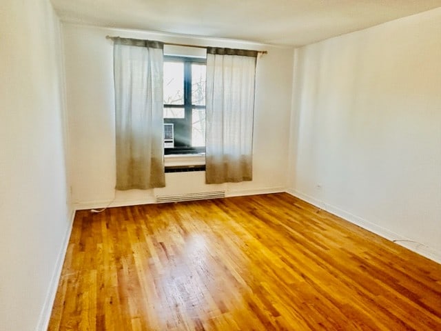 empty room featuring hardwood / wood-style flooring and cooling unit