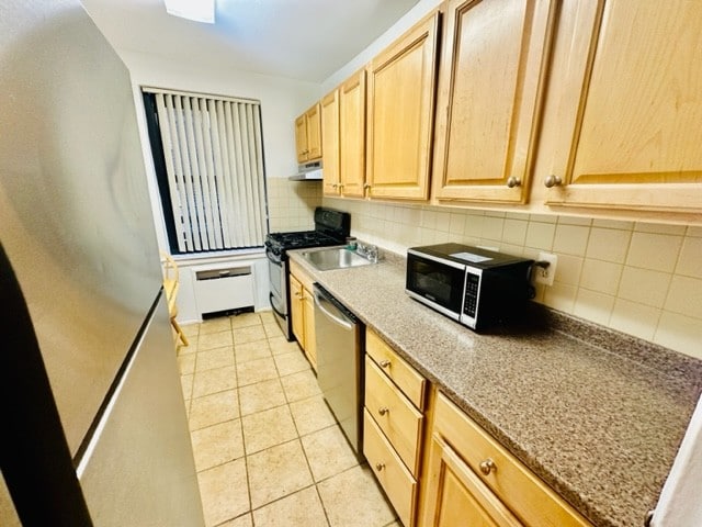 kitchen with appliances with stainless steel finishes, decorative backsplash, sink, light brown cabinetry, and light tile patterned flooring