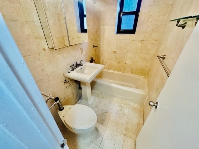 bathroom with toilet, tiled shower / bath combo, and tile patterned floors