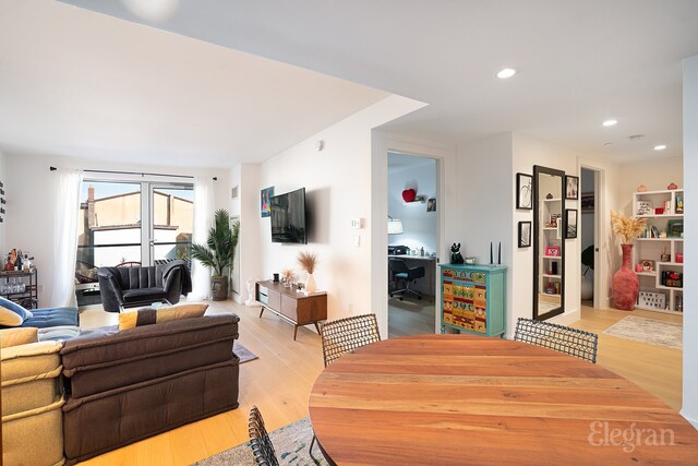 game room featuring light wood-type flooring, pool table, and a tray ceiling