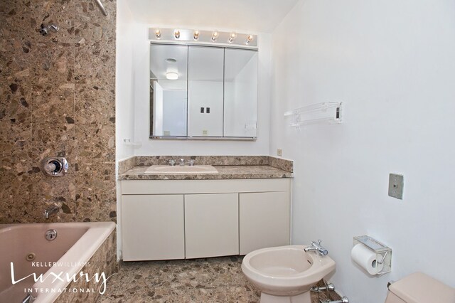 full bathroom featuring toilet, vanity, a bidet, and tiled shower / bath