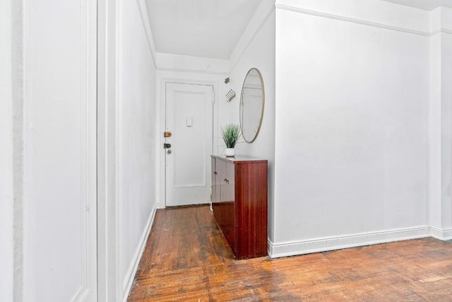 hallway featuring baseboards and dark wood-type flooring