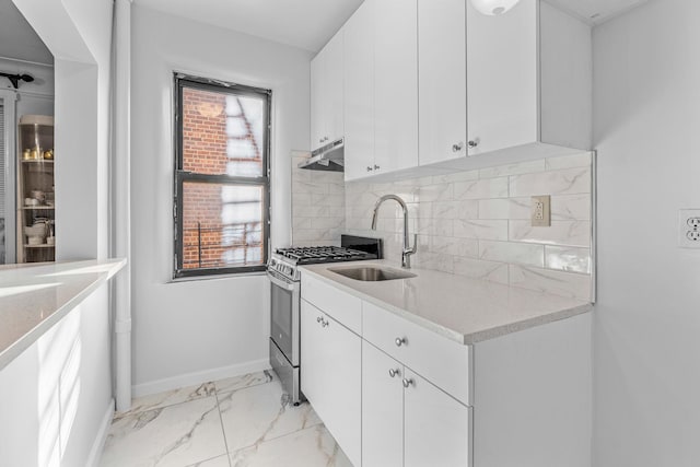 kitchen with a sink, under cabinet range hood, stainless steel gas range, light marble finish flooring, and white cabinets