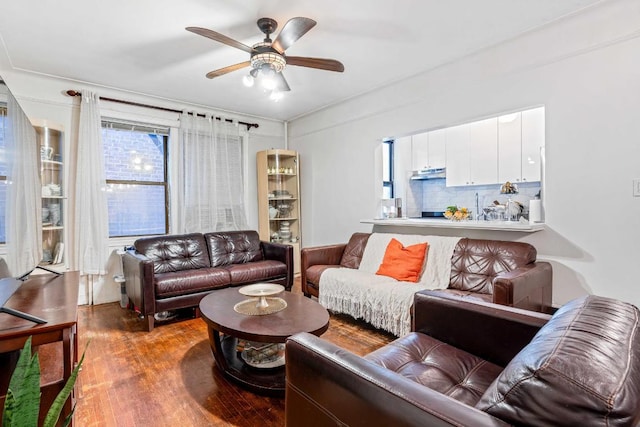 living area with ceiling fan and dark wood-style flooring