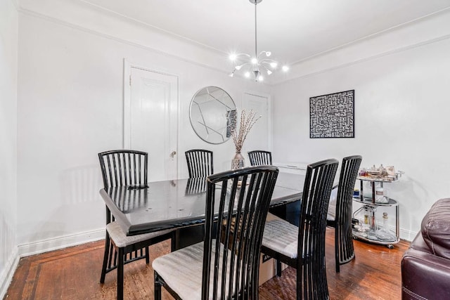 dining area featuring a notable chandelier, baseboards, and wood finished floors