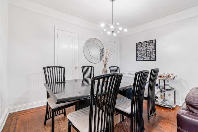dining room with wood finished floors, a chandelier, and baseboards