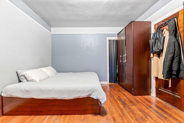 bedroom with wood finished floors and a closet
