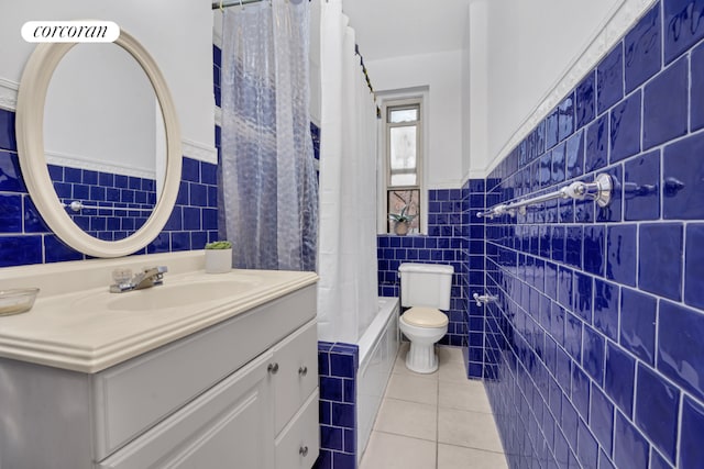 bathroom with tile walls, toilet, vanity, and tile patterned flooring