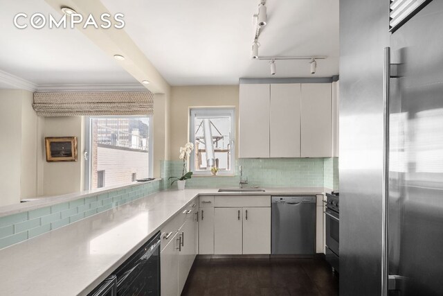 kitchen featuring sink, white cabinetry, backsplash, and high quality appliances