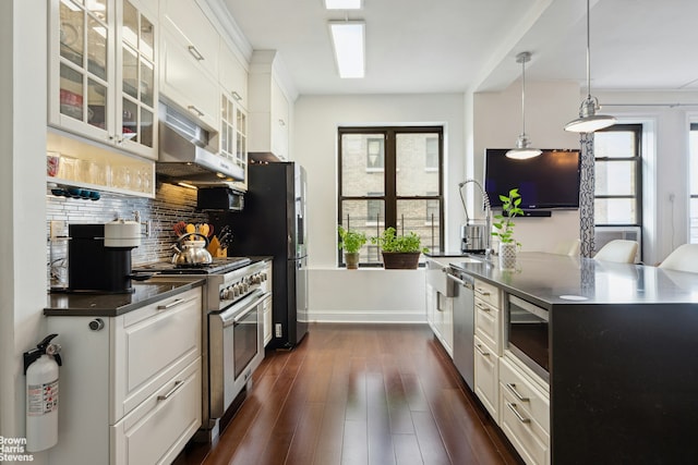 kitchen with backsplash, pendant lighting, white cabinetry, dark wood-type flooring, and appliances with stainless steel finishes