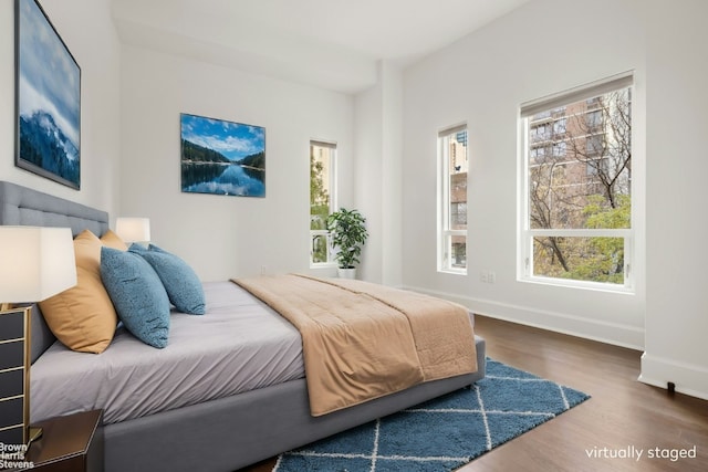 bedroom featuring dark wood-style flooring and baseboards