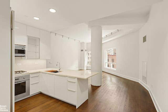 kitchen featuring light countertops, appliances with stainless steel finishes, a peninsula, and a sink