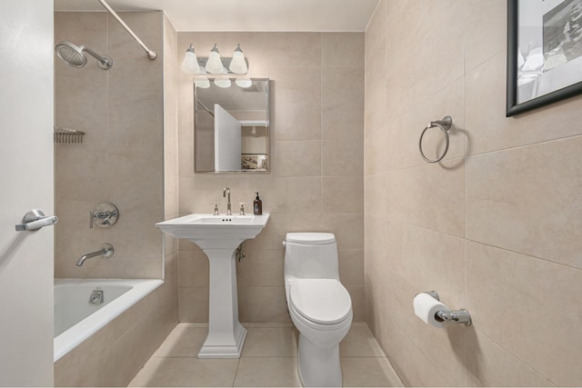 full bathroom featuring toilet, tiled shower / bath, tile walls, and tile patterned floors