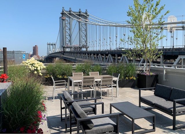 view of patio / terrace with outdoor dining area, an outdoor living space, and a city view