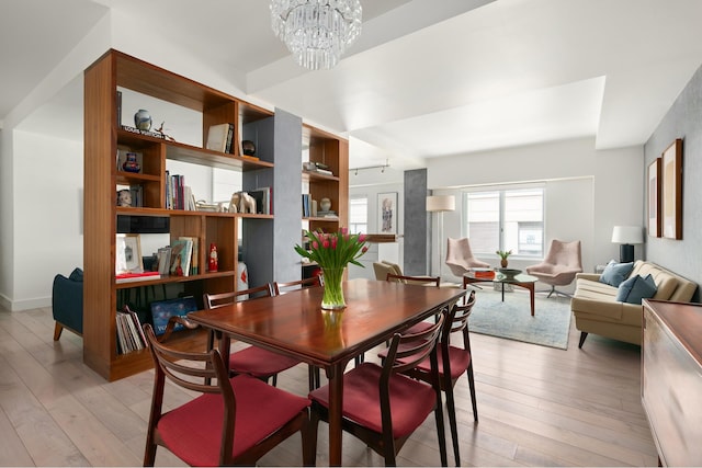 dining area featuring light wood finished floors and an inviting chandelier