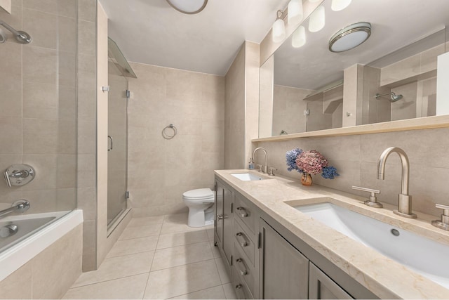 full bath with tiled shower, tile patterned floors, a sink, and tile walls