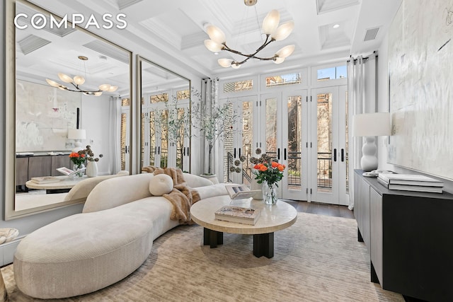 interior space with a chandelier, visible vents, coffered ceiling, and ornamental molding