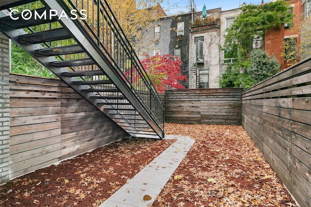 view of yard featuring stairs and fence