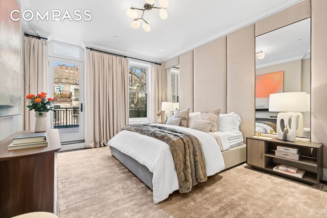 bedroom featuring crown molding, access to exterior, and a chandelier