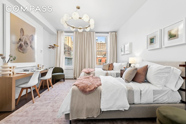 bedroom with wood finished floors and a chandelier