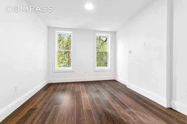 empty room with dark wood-style floors and baseboards