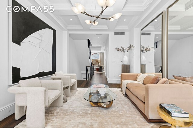 living room with hardwood / wood-style flooring, ornamental molding, coffered ceiling, and a chandelier