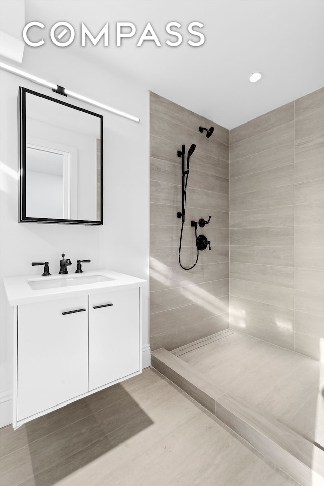 bathroom with vanity and a tile shower