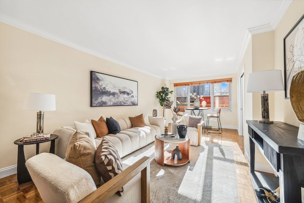 living area with baseboards and ornamental molding