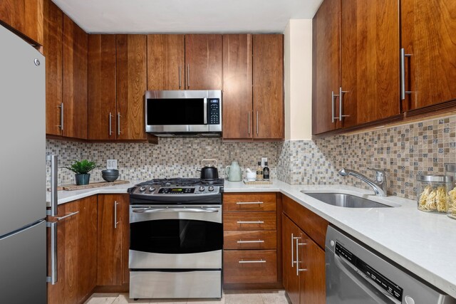 kitchen with tasteful backsplash, appliances with stainless steel finishes, and sink