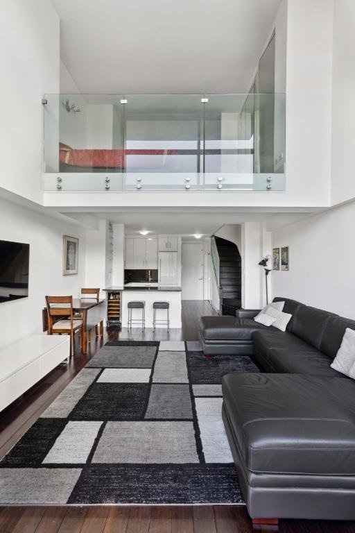 living room with a towering ceiling and dark hardwood / wood-style floors