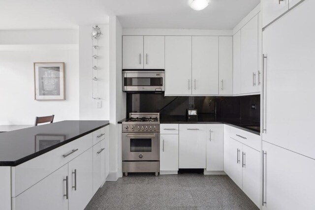 kitchen with appliances with stainless steel finishes, white cabinets, and decorative backsplash