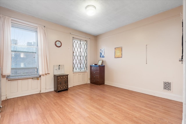 interior space with baseboards, visible vents, and wood finished floors