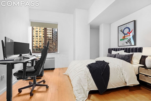 bedroom featuring light wood-type flooring and radiator heating unit