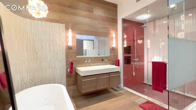 bathroom with vanity, independent shower and bath, and wood walls